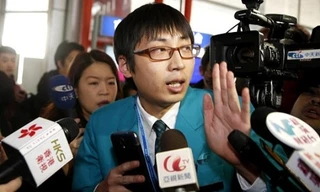 Một nhân viên của Malaysia Airlines trong vòng vây phóng viên.