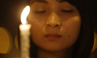 Một cô gái cầm nến cầu nguyện cho chiếc máy bay mất tích