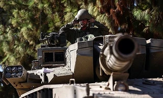 Một người đàn ông ngồi giữa hiện trường vụ đánh bom vào trại tị nạn Jabalia ở phía bắc Dải Gaza ngày 1/1. (Ảnh: Reuters)