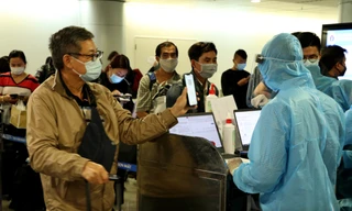Nhân viên kiểm dịch kiểm tra khai báo y tế, hộ chiếu người nhập cảnh tại sân bay Tân Sơn Nhất - ảnh: Ngô Bình, mạnh thắng