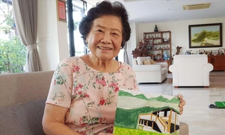 Bà Tú Anh với bức tranh vẽ ngôi nhà sàn, nơi đồng chí Hoàng Văn Thụ sinh ra và lớn lên Ảnh: kiến nghĩa