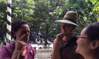 Vợ chồng nhà báo Úc Laura Watkins trò chuyện với dân xóm đường tàu sáng 10/10. Họ là du khách hiếm hoi vào được đây.