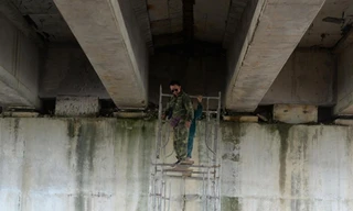 Công nhân sửa chữa cầu chui bị thấm, dột nước. Ảnh: N.T 