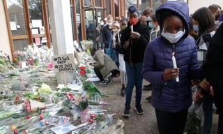 Nhiều người đến trường đặt hoa tưởng niệm thầy giáo bị giết hại Ảnh: AP 