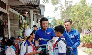 Anh Trần Quốc Bủ, Bí thư Đoàn xã Đất Mới (thứ hai, từ trái sang) phát tờ rơi phòng chống đuối nước cho các em học sinh 