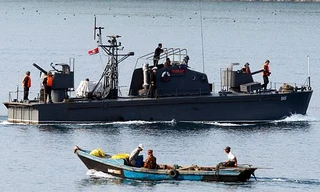 Một thuyền đánh cá Triều Tiên đi ngang tàu tuần tra của hải quân nước này. Ảnh: AP 