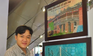 Anh Khưu Tấn Bửu, chủ cơ sở tranh gạo Tấn Bửu bên sản phẩm của mình.   ẢNH: HÒA HỘI 