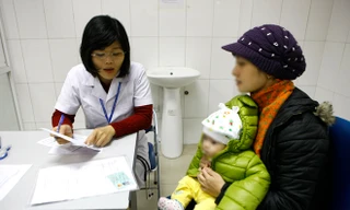 Đưa trẻ đi khám dinh dưỡng ở một trạm y tế Hà Nội. ảnh: như ý