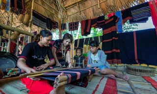 Trần Thị Một (thứ 2 từ trái sang) hướng dẫn các bạn trẻ cách dệt thổ cẩm truyền thống của người Cơ Tu. Ảnh: NVCC