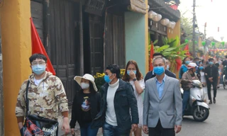 Khách du lịch đeo khẩu trang khi tham quan phố cổ Hội An 
