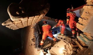 Lực lượng cứu hộ tìm kiếm nạn nhân trong ngôi nhà sập vì động đất ở tỉnh Cam Túc ngày 19/12. (Ảnh Reuters)