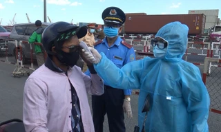 Nhân viên y tế đo thân nhiệt người dân tại các chốt kiểm soát phòng chống COVID-19.