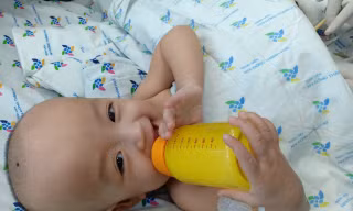 Các bé tự cầm bình sữa uống mà không cần trợ giúp của người lớn.