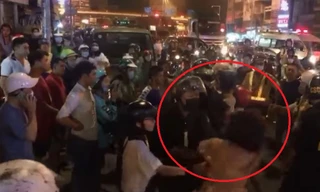 Cô gái giằng co, cắn tay Cảnh sát cơ động (ảnh cắt từ Clip).