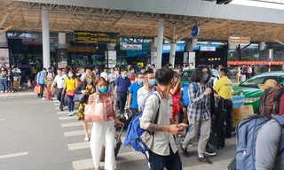 Hành khách đi bộ cắt ngang các làn ô tô trước ga quốc nội.