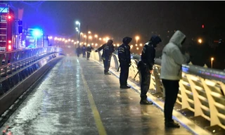 Cảnh sát và nhân viên cứu hộ đứng trên thành cầu, nơi con tàu được tìm thấy và công tác cứu hộ đang được tiến hành khẩn trương. Ảnh: Getty Images. 