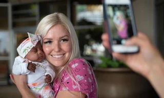 Bé Saybie trong vòng tay của y tá chăm sóc đã được xuất viện sau gần 5 tháng được chăm sóc đặc biệt.