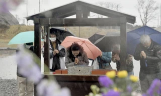 Người dân tới cầu nguyện tại trường tiểu học Okawa ở Ishinomaki, tỉnh Miyagi sáng 11/3. Ngôi trường này có hơn 80 học sinh và giáo viên bị thiệt mạng trong vụ động đất sóng thần 8 năm trước và hiện đã bị đóng cửa. Ảnh: Kyodo news.