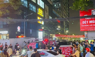 Xe ô tô mang theo băng rôn phản đối đơn vị quản lý, vận hành tự ý tăng phí trông giữ trên đường Nguyễn Tuân chiều tối 19/4