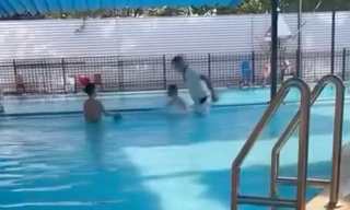 Hình ảnh người đàn ông dúi đầu cháu bé tại bể bơi