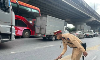 Cán bộ, chiến sỹ Đội CSGT đường bộ số 7 xử lý vết dầu loang tránh nguy hiểm cho người tham gia giao thông