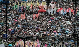 Nhiều người Hong Kong mang theo ô khi biểu tình để vừa che nắng vừa chống bị cảnh sát xịt hơi cay. Ảnh: Philippe Lopez