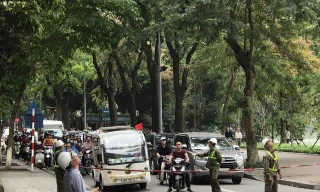 Nhân viên Cty TNHH MTV Công viên Cây xanh Hà Nội giăng dây chắn đường phục vụ cắt tỉa cây xanh.