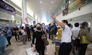 Hai người trong đội ngũ phòng dịch tại sân bay Nội Bài tranh thủ chợp mắt khi không có khách làm thủ tục. 