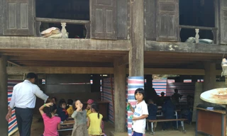 Học sinh túm tụm ngồi học nhờ dưới gầm nhà sàn của dân