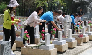 Các thành viên trong đoàn thắp hương tại phần mộ các liệt sĩ. 