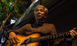 Người "nghệ sĩ xe ôm" già với cây đàn guitar.