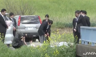 Cha mẹ bé Nhật Linh thắp hương cho con gái tại nơi phát hiện thi thể bé. Ảnh: Kyodo