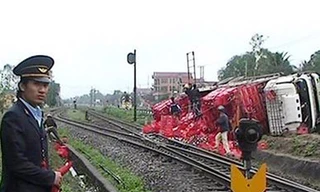 Ô tô chở bia lật sát đường tàu