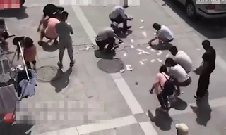 Người dân tranh nhau nhặt tiền trên trời rơi xuống.