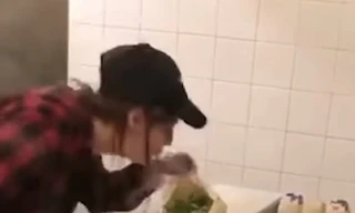 Nữ nhân viên nhổ nước bọt vào bánh sandwich cho khách. Ảnh cắt từ video