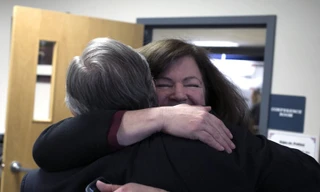 Đại diện tổ chức End 68 Hours of Hunger xúc động khi nhận được khoản tiền quyên góp từ người phụ nữ trúng độc đắc giấu tên. Ảnh: AP