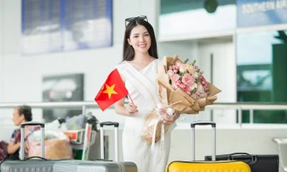 Hoa khôi Huỳnh Thúy Vi cầm hoa và cờ Việt Nam trước giờ lên máy bay.