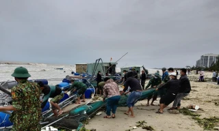 Lực lượng chức năng cùng người dân nỗ lực cứu lồng bè cá bị cuốn ra biển. 