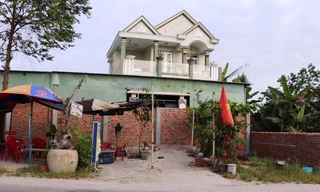 Ngôi nhà hai tầng khang trang nhưng bị một bức tường rào hơn 2 mét chắn ngang trước cổng.