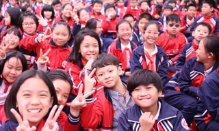 Các em học sinh trường Tiểu học Dịch Vọng A (Cầu Giấy, Hà Nội) hào hứng tại lễ phát động cuộc thi sưu tập và tìm hiểu tem Bưu chính "Cháu ngoan Bác Hồ mừng Đảng quang vinh". Ảnh: Bảo Anh