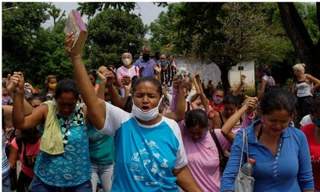 Người thân của các tù nhân ở nhà tù Los Llanos đứng ngoài cầu nguyện cho các nạn nhân vụ thảm sát trong tù.