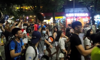 Nhiều người trẻ cầm chảo, đội mũ bảo hiểm đi trên phố (Ảnh: X.T)