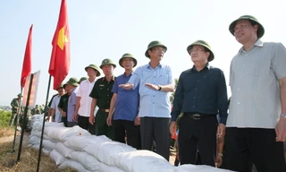 Phó Thủ tướng Trịnh Đình Dũng nghe báo cáo của Bí thư Tỉnh ủy Nguyễn Văn Đọc về phương án bảo vệ, gia cố tuyến đê Hà Nam (TX. Quảng Yên). Ảnh: BQN