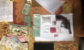 Tang vật súng ru-lô, ma túy, tiền, đô-la thu giữ từ đối tượng ma túy.