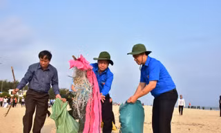 Chủ tịch Phan Ngọc Thọ (giữa) hăn hái gom nhặt rác, góp phần làm sạch môi trường bãi tắm Thuận An