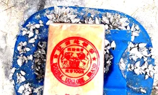 21 bánh hình chữ nhật bao gói bằng nylon có in hình dạng khuôn dấu kèm chữ Trung Quốc và ký tự Latinh chứa trong can nhựa này vừa được người dân phát hiện tại bờ biển xã Quảng Ngạn, huyện Quảng Điền, tỉnh TT-Huế