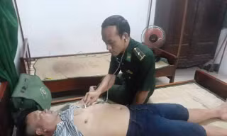 Kiểm tra sức khỏe ngư dân bị đắm thuyền sau khi được bộ đội biên phòng và dân địa phương đưa vào bờ an toàn