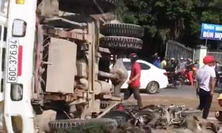 Chiếc xe ben lật ngang đường đè 2 xe máy.