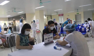 Người dân đăng ký thông tin để làm thủ tục tiêm vắc xin tại Bệnh viện E Trung ương. 