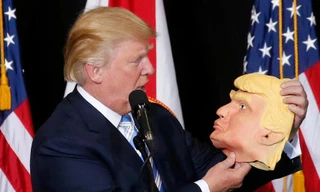 Ông Donald Trump, ứng viên đảng Cộng hòa, cầm trên tay chiếc mặt nạ hình ông tại điểm vận động tranh cử ở Sarasota, Florida tối ngày 7/11 (giờ địa phương).